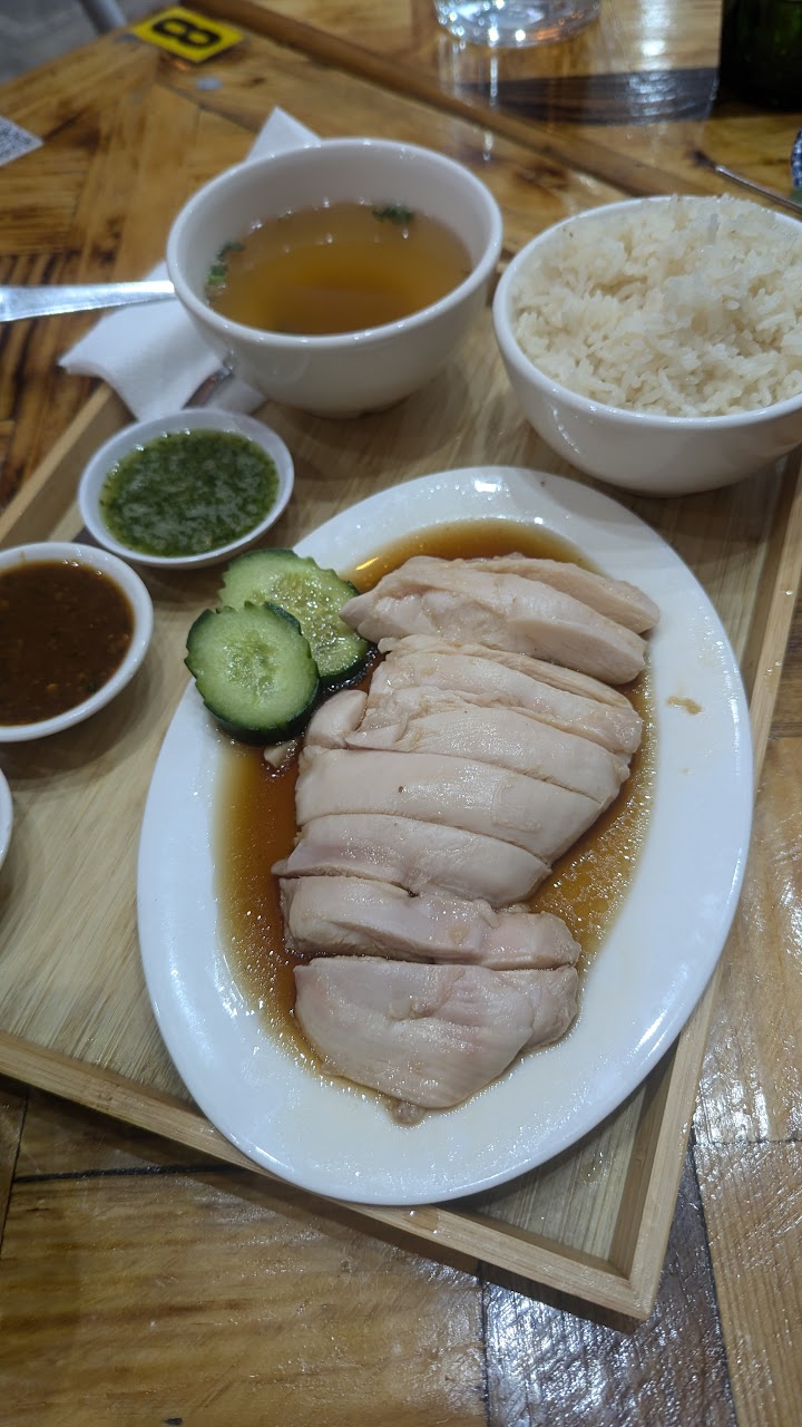 Khao Man Kai poached chicken rice with broth, sauces, cucumber, and rice